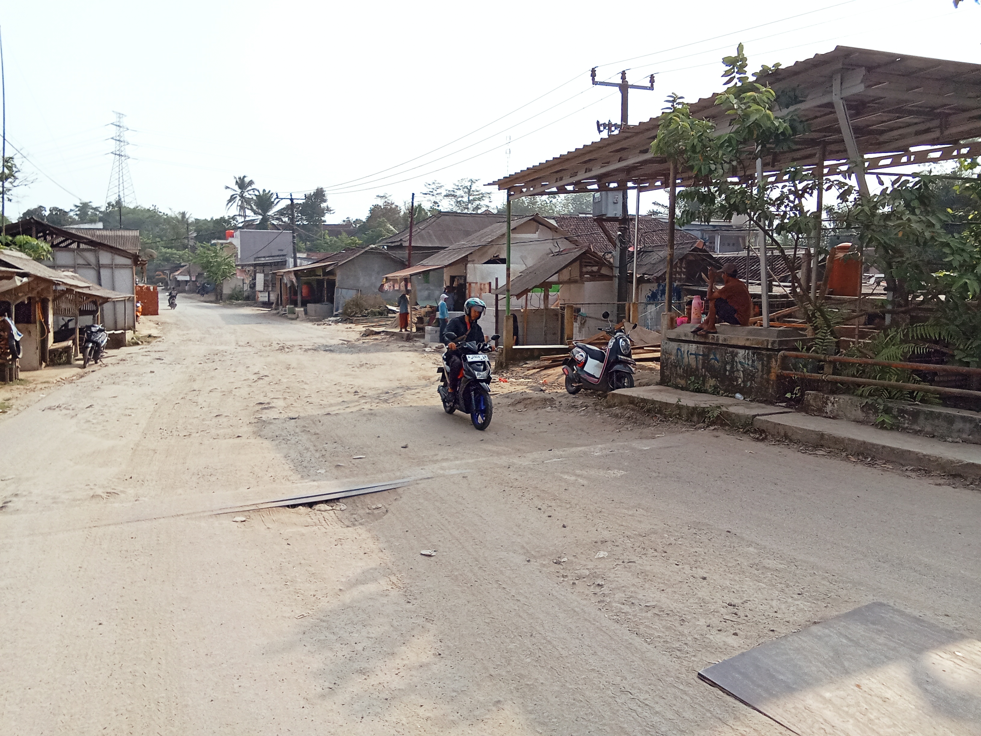 Poto /Jalanan yang berlobang dan banyak matrial pasir
